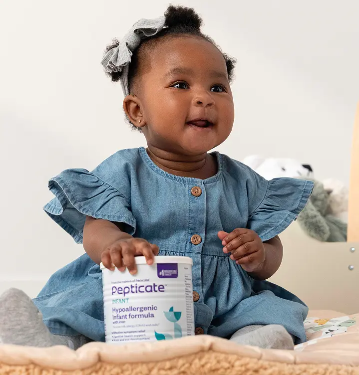 A baby sitting with a can of Pepticate formula