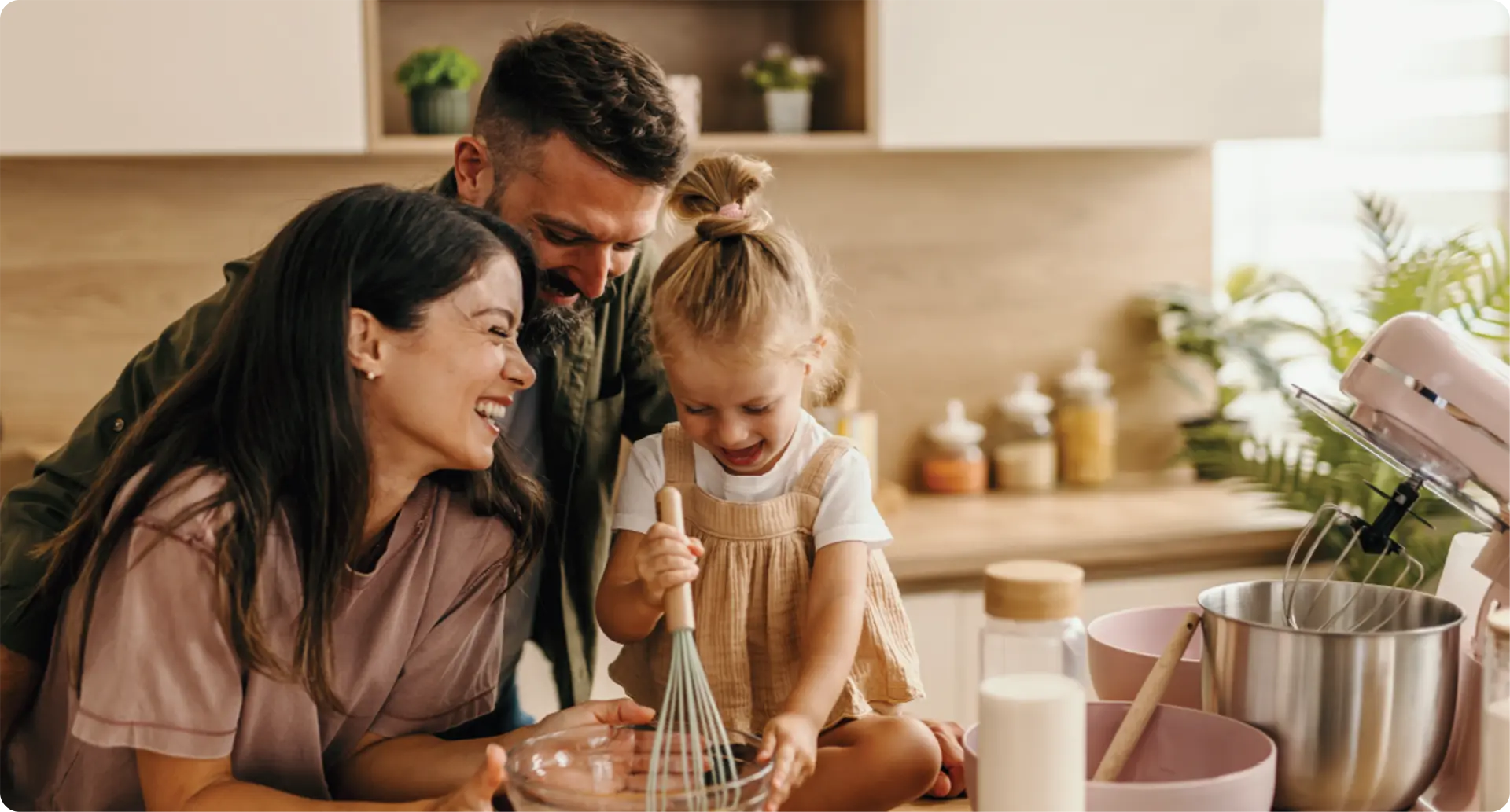A mother and father preparing food with a young child